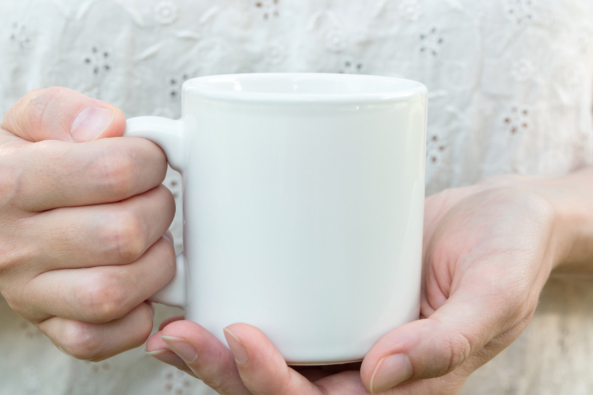 Young Caucasian Woman Holding a White Mug, Mock up, Blank Space